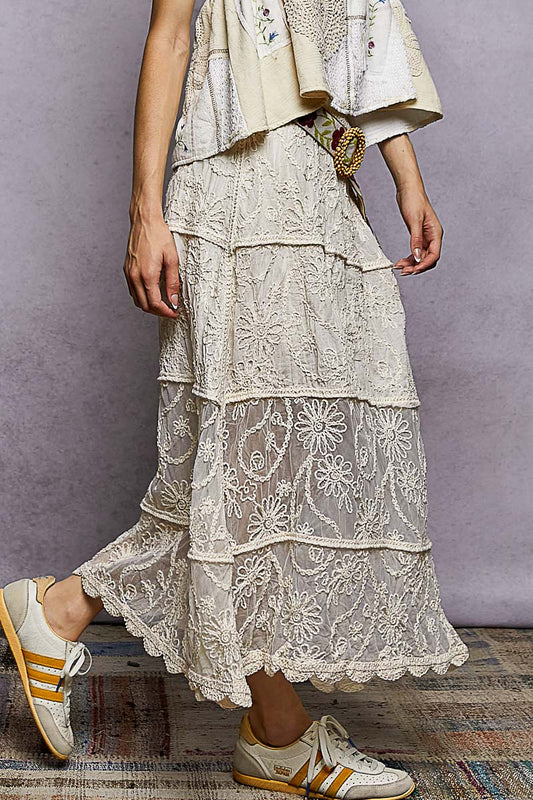 Left side profile of floral lace crochet skirt, tiered hemline falling naturally, border detail along each tier, relaxed fit