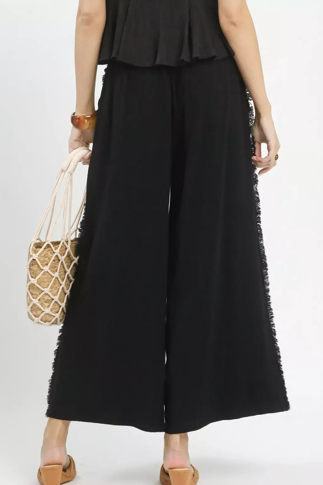 Back view of women's linen frayed wide leg pants showing flowy fit and comfortable relaxed summer style