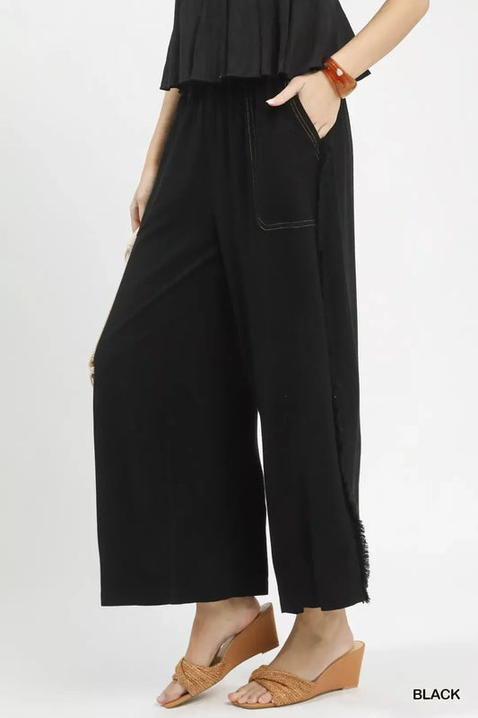 Side view of linen wide leg pants highlighting frayed hem and functional side pockets for casual summer style