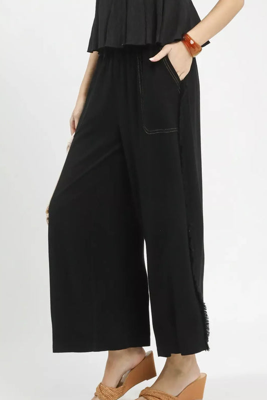 Side view of linen wide leg pants highlighting frayed hem and functional side pockets for casual summer style