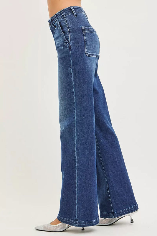 Side view of RISEN high rise wide leg slanted pocket jeans showing the high waist rise, relaxed hip fit, and flowing wide leg drape on a female model.