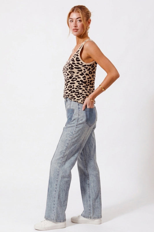 Front view of SO ME leopard knit V neck tank top with model's hand in back pocket showing V neckline depth, sleeveless design, and soft knit drape.