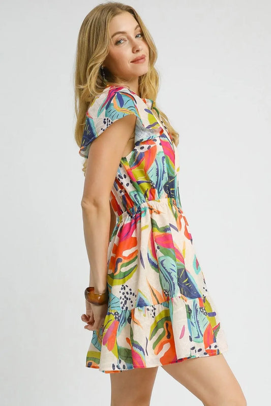 Side profile of woman wearing lined tropical print dress, relaxed fit through body, smocked waist creating feminine silhouette, lightweight rayon nylon fabric draping naturally