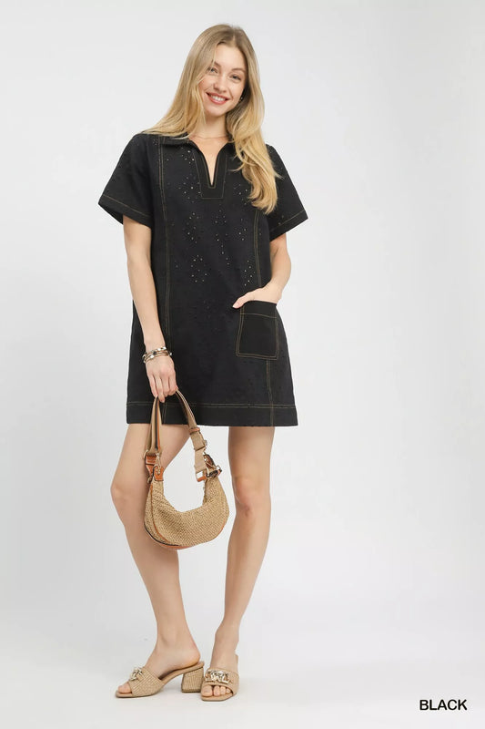 Front closeup of the Umgee eyelet short sleeve shift dress, highlighting the eyelet detail, round neckline, and front pocket.
