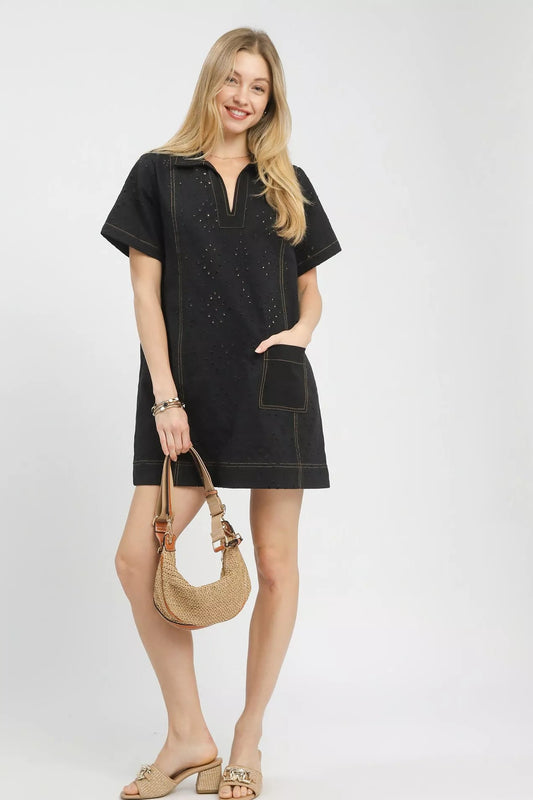 Front closeup of the Umgee eyelet short sleeve shift dress, highlighting the eyelet detail, round neckline, and front pocket.