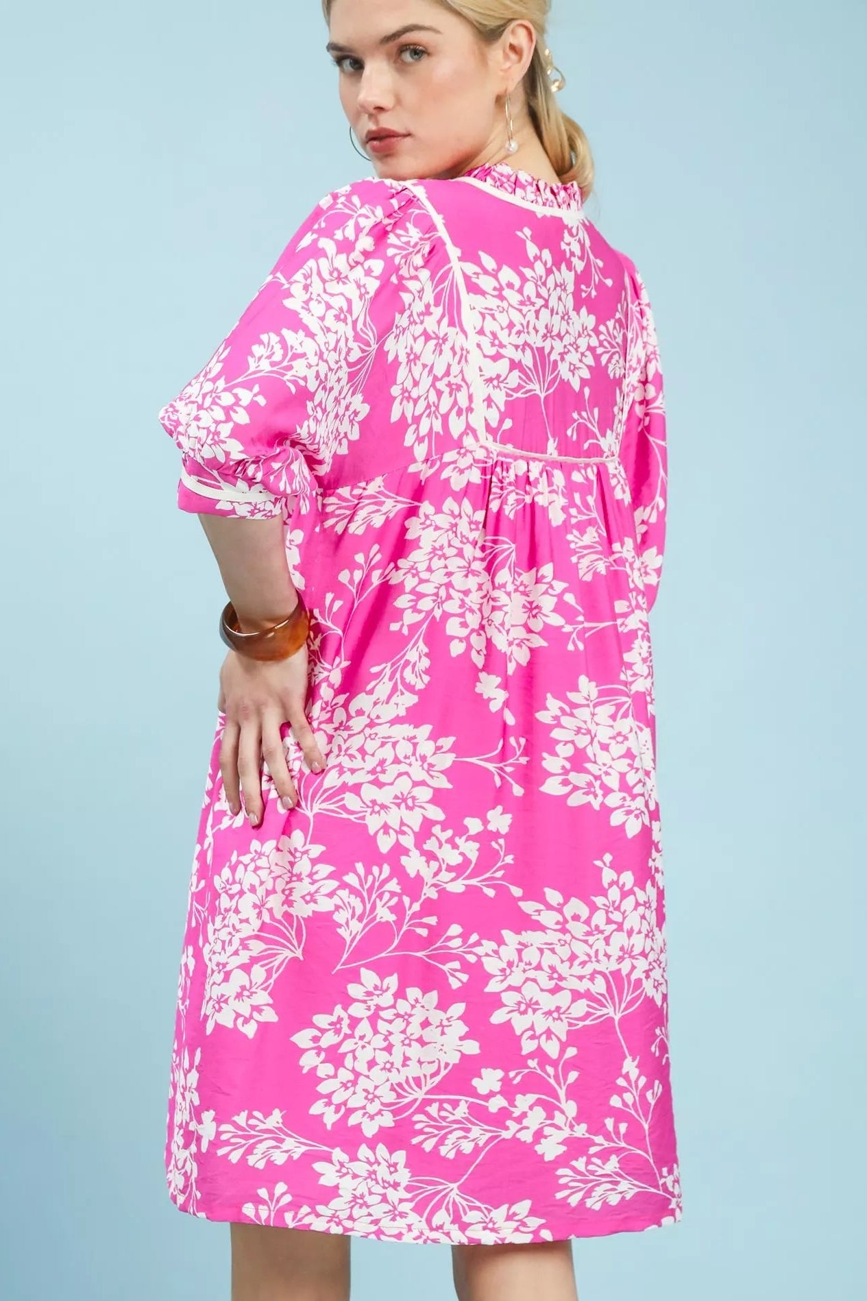 Back view of Umgee floral babydoll dress with pockets showing overall floral design and fit