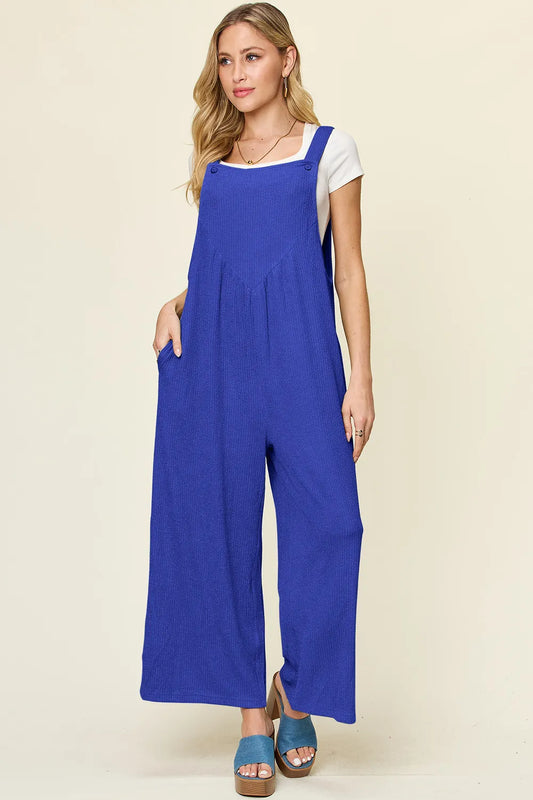 Side profile of Centprime Double Take wide leg jumpsuit showing flowy silhouette and comfortable stretch fit in blue