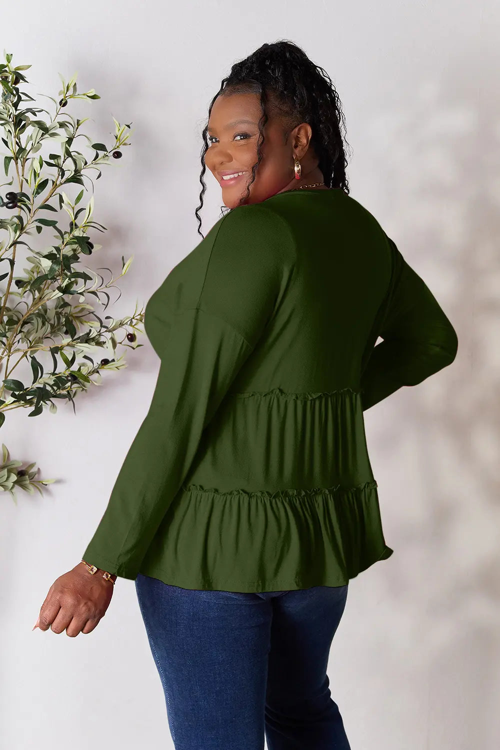 Relaxed back view of Double Take ruffle hem blouse on model.
