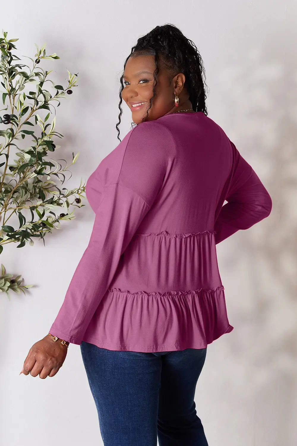 Three-quarter turned back view of Double Take half button long sleeve ruffle hem blouse.
