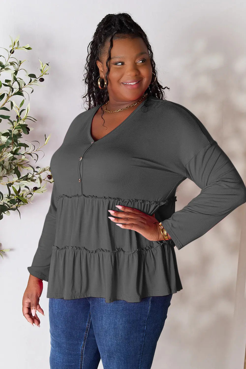 Side view of Double Take half button long sleeve ruffle hem blouse showing drape.
