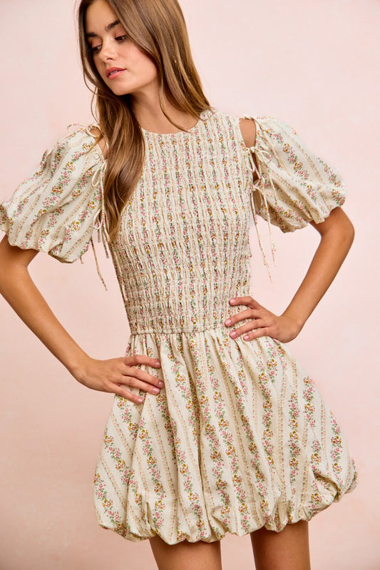 Front view of floral bow tie dress with attachable puff sleeves removed, showing sleeveless silhouette and adjustable tie neck, 100 percent cotton lined dress