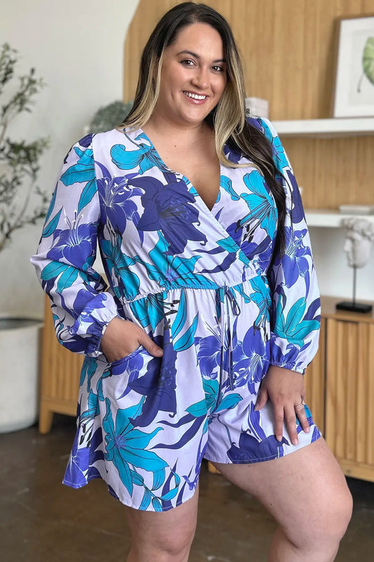 Model with hand inserted into side seam pocket of floral long sleeve romper demonstrating functional pocket feature