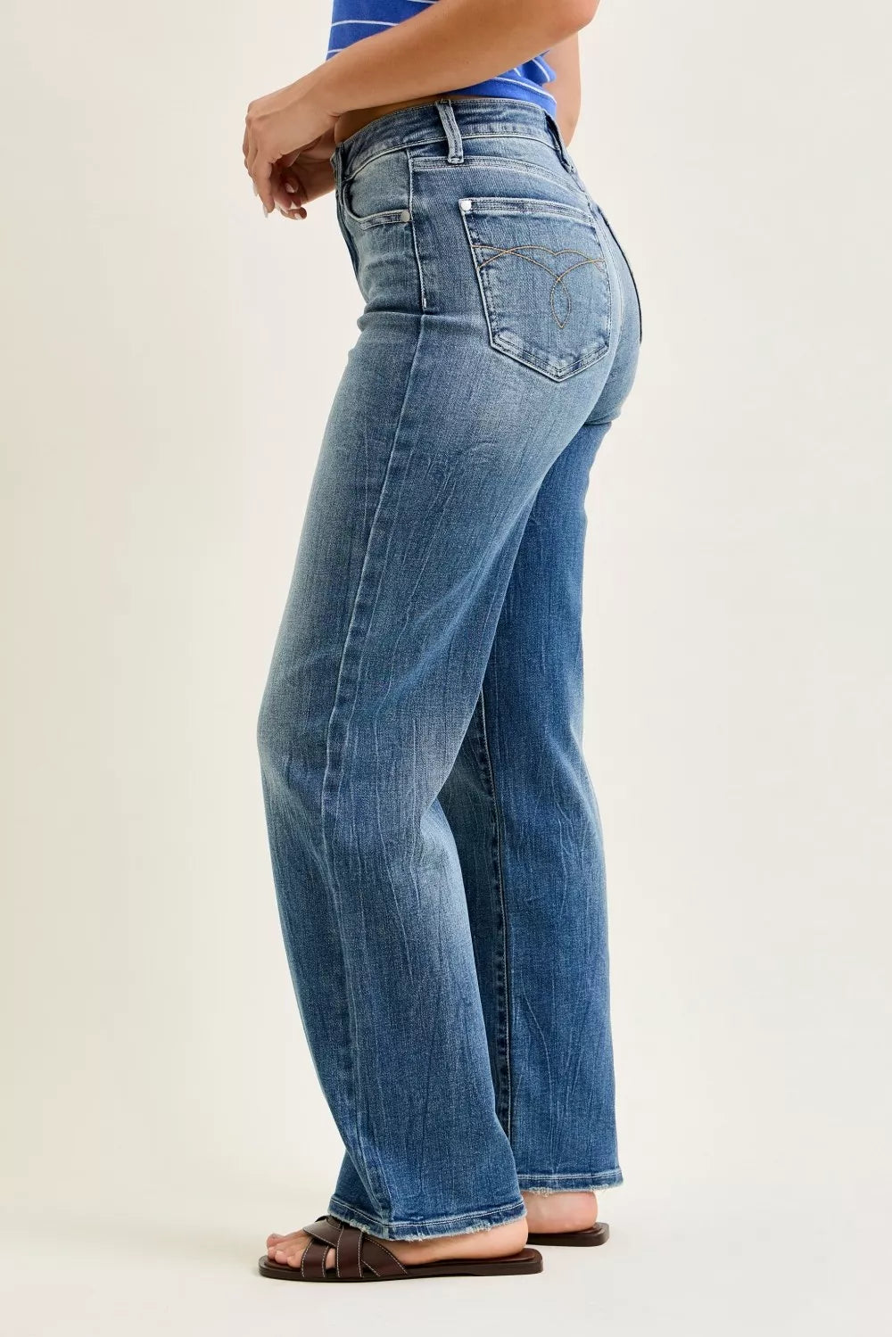 Judy Blue mid rise 90s straight leg jeans for women model standing facing side left, left side view of straight leg denim jeans with mid-rise fit