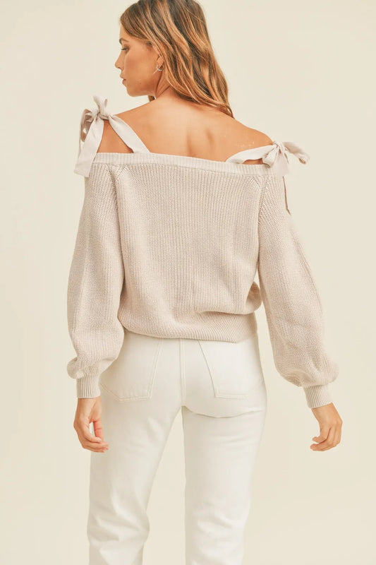Back view of MABLE Off Shoulder Self Tie Strap Button Down Sweater showing adjustable straps and soft knit fabric with button detail
