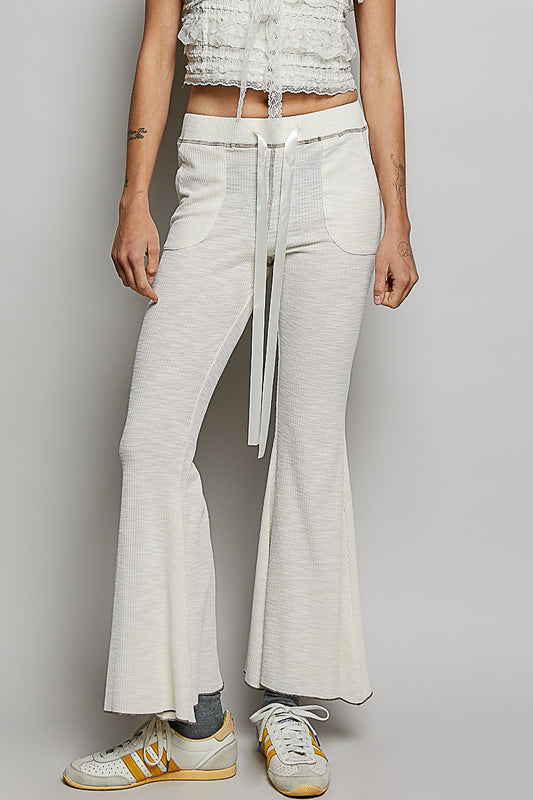 Women's POL drawstring ribbed knit flare pants front view featuring adjustable waistband, textured fabric, and functional front pockets on a model standing straight.