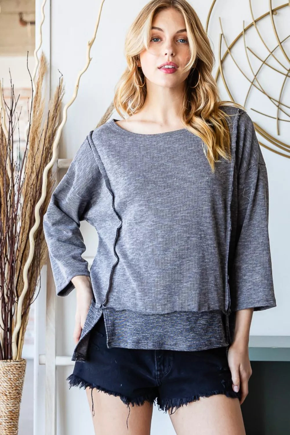 Front view of the Reborn J boat neck exposed seam slit top, showing the relaxed fit, long sleeves, and soft knit fabric.

