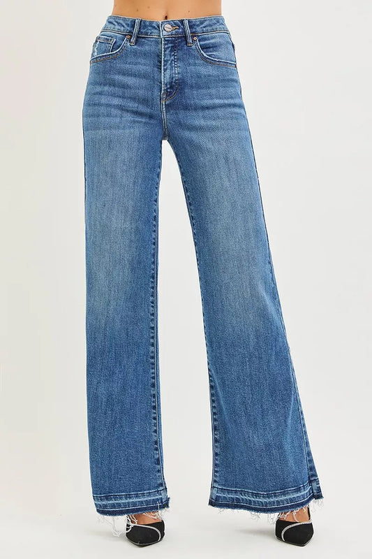 RISEN high rise wide leg jeans with released hem front view, raw hem denim in medium blue wash, slightly stretchy wide leg jeans standing straight on model