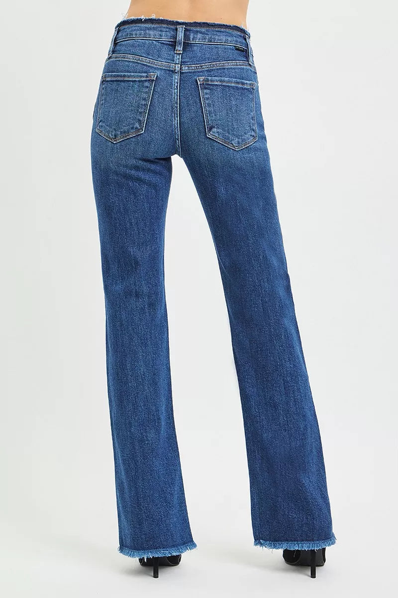 RISEN mid rise bootcut jeans back view, model facing away, frayed waistband across back, raw hem detail, relaxed bootcut fit through leg