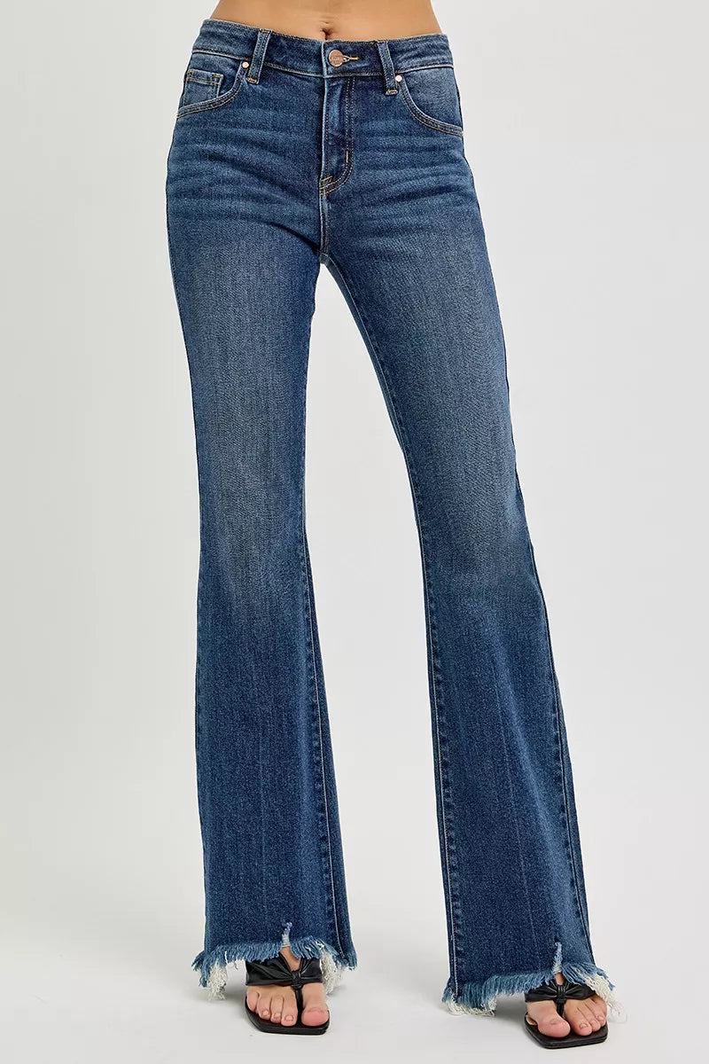 Front closeup of RISEN mid rise flare frayed hem jeans, highlighting the waist, pockets, and frayed hem detail in plus size denim.
