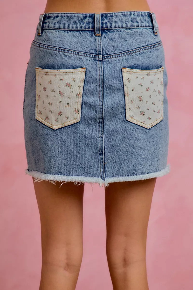 Back view of SO ME washed denim floral mini skirt showcasing denim floral design and flattering fit for women’s fashion