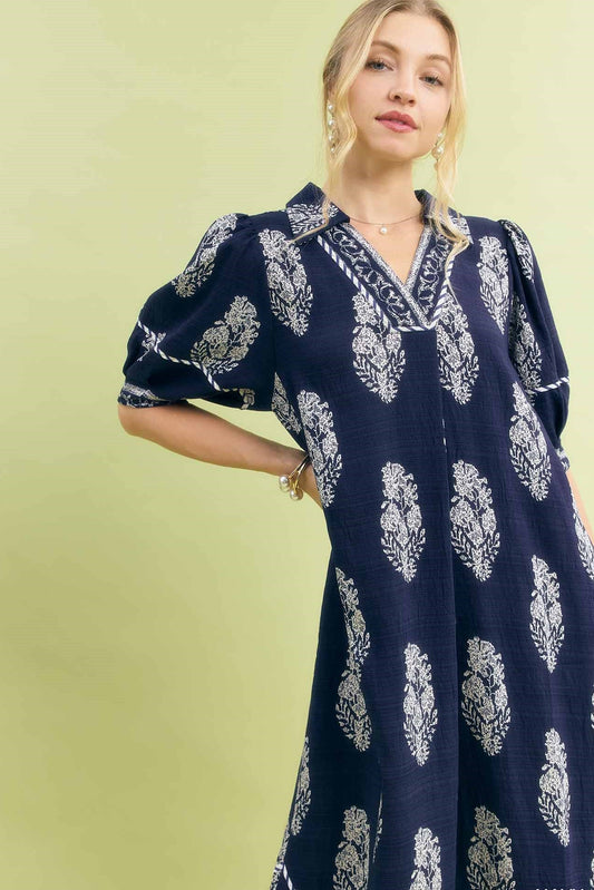 Up close view of Umgee border print midi dress showing relaxed fit, side pocket placement, and midi length hemline.