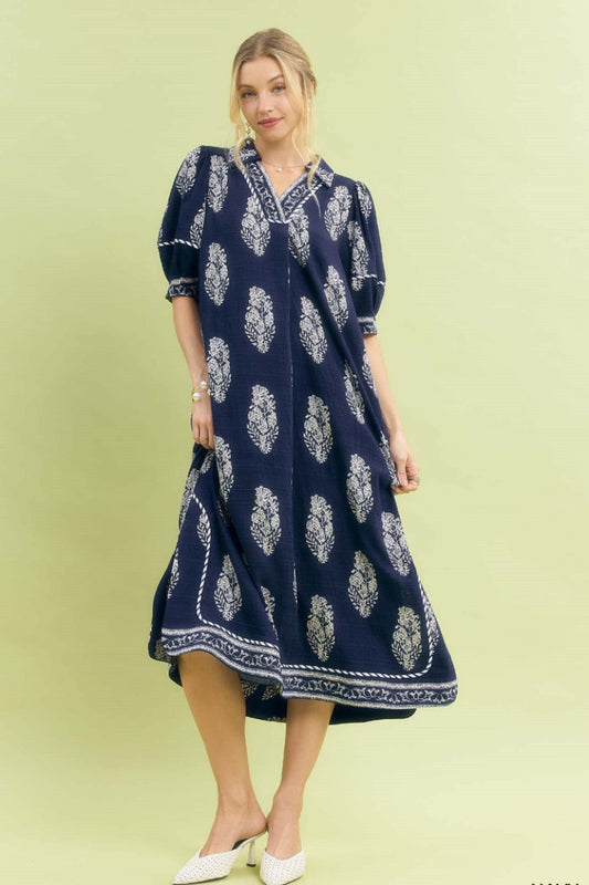 Front view of Umgee border print collared midi dress in navy paisley with V-neck, puff sleeves, and button-front closure.