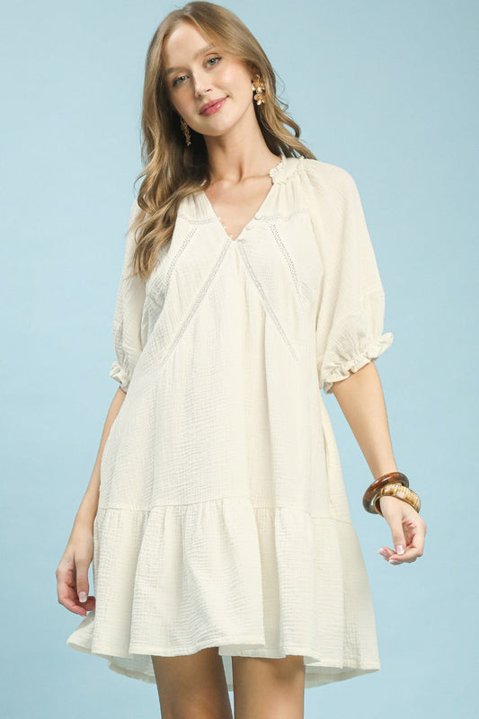 Umgee cotton gauze mini dress front view on model standing straight showing buttoned front, tiered skirt, lace detail, and flowy A-line silhouette.