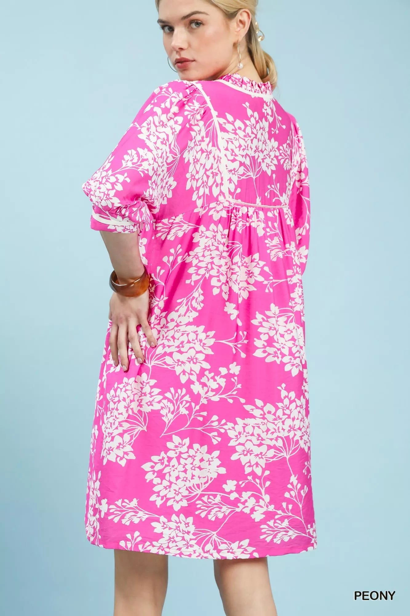 Back view of Umgee floral babydoll dress with pockets showing overall floral design and fit
