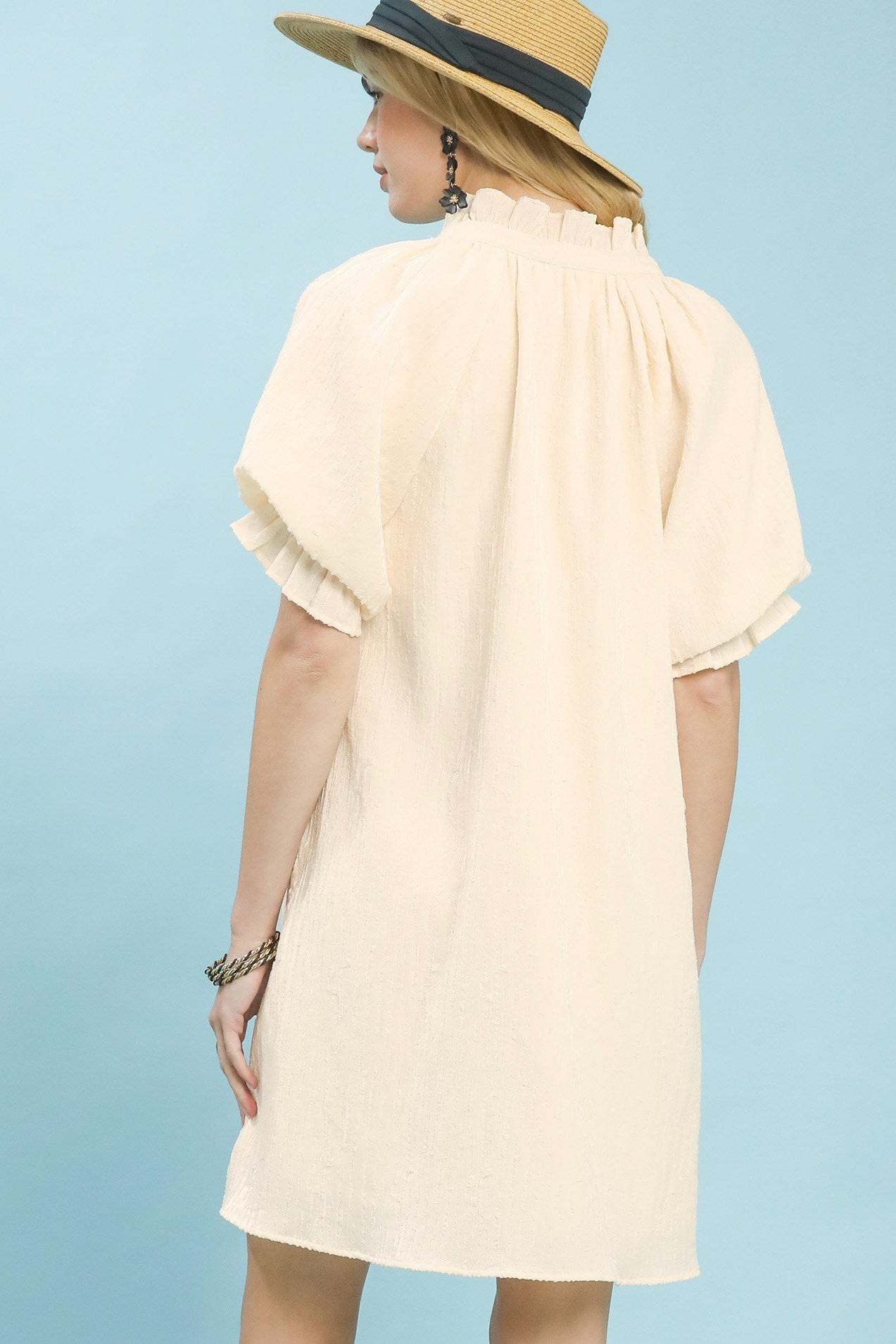 Back view of Umgee linen blend ruffle dress. Open keyhole or button closure at back. Ruffles continue evenly around hem. Loose comfortable fit. Romantic cottagecore aesthetic.