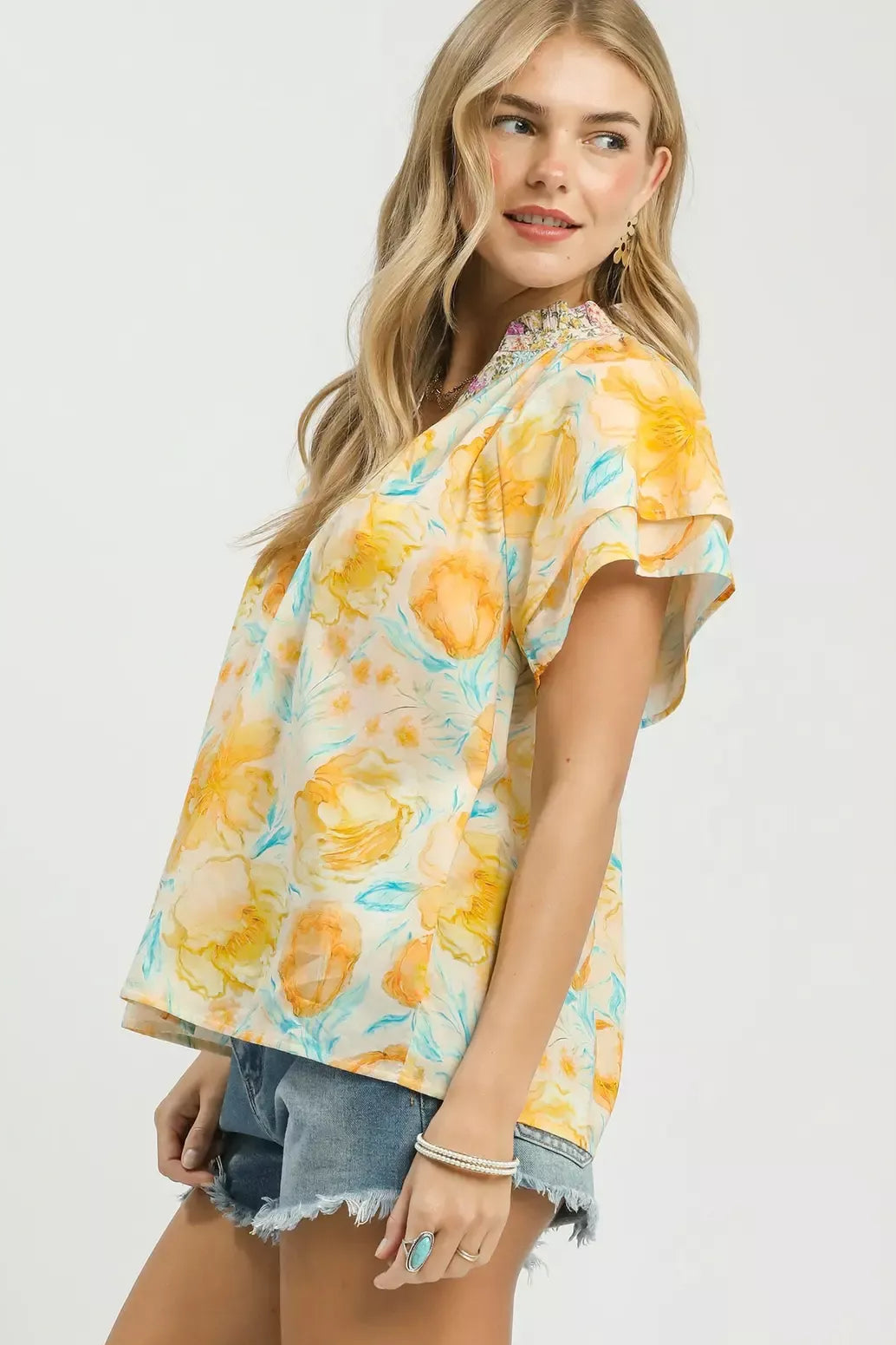 Umgee Mixed Floral Blouse with Crochet Lace Trim side view - sheer or lightweight blouse with flutter sleeves extending from shoulder, crochet lace detailing, and easy breezy side drape

